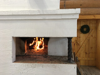 The fire in the old traditional russian village oven in a rustic style.   Frame of  burning wood on...