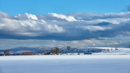 Winter farmland view with snowy fields and clouds in eastern Oregon.