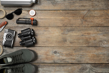 Flat lay composition with different safari accessories on wooden background, space for text