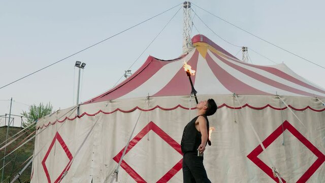Circus artist performing fire breathing trick