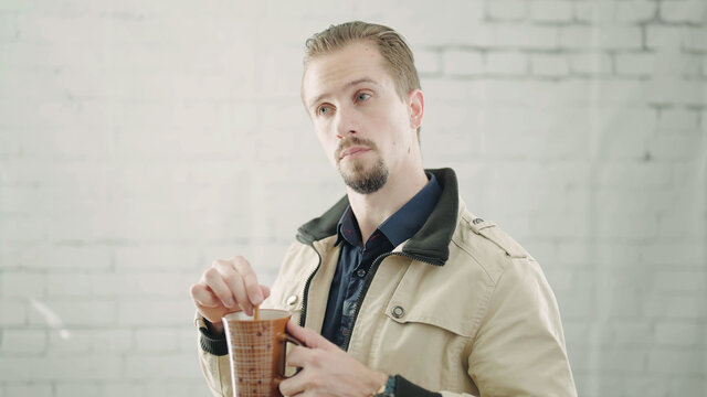 Man With Mug Mixing And Making A Say What Expression