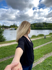 A woman holding hand of somebody. Attractive female person outdoors.