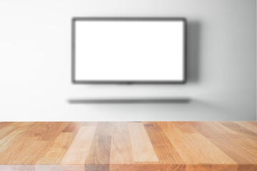 empty wooden table top with tv in living room blurred background.