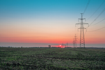Electricity pole with silhouette sunset sky, Electricity pylon with shadow of tree in dawn time, Electricity power transmission line on sunset with copy space