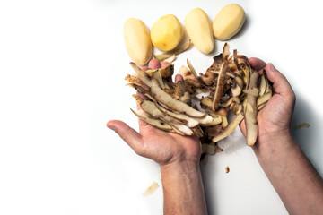 The guy peels potatoes on a white background, next to it lies potatoes and lush rations