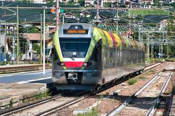 A colorful train enters Merano Station - obrazy, fototapety, plakaty