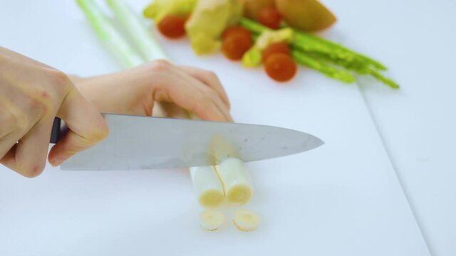 Hands cutting leeks preparing for cooking