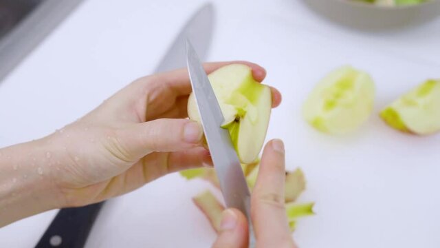  Closeup of hands holding an apple and cut it with knife.