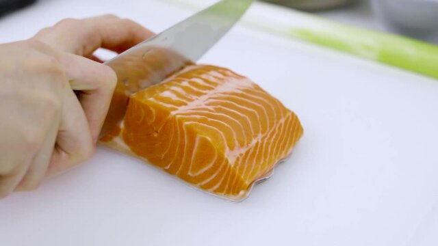 Closeup - home cooking cutting salmon preparing for sashimi and for preserved in shoyu.