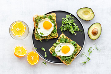 Toasts with eggs and avocado cream and spinach. Top view