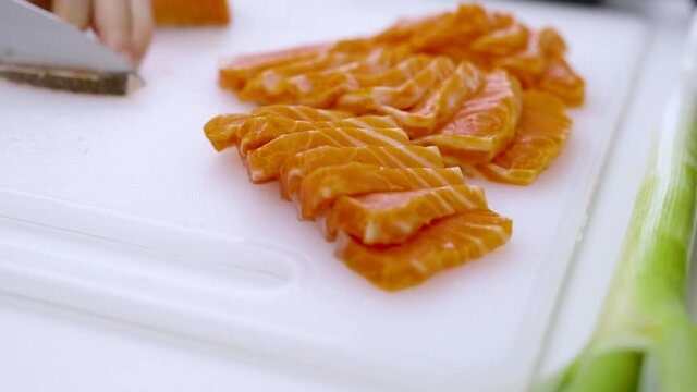 Closeup - home cooking cutting salmon preparing for sashimi and for preserved in shoyu.