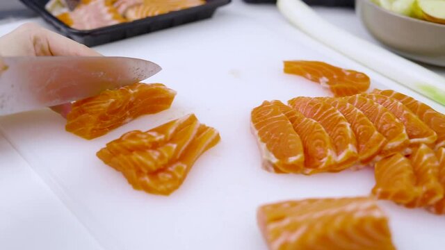 Closeup - home cooking cutting salmon preparing for sashimi and for preserved in shoyu.