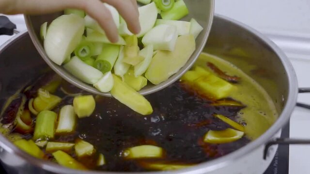 Pouring vegetable into boiling Choyu stock.
