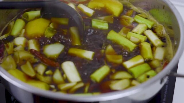 Stirring choyu stock with black ladle