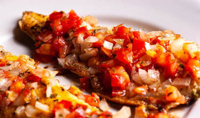 Grilled trout in tomato sauce with onion and pepper. In the background carrot, cabbage and pickle salad