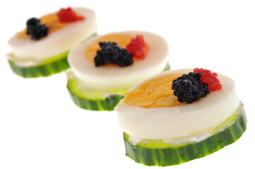 Amuses-bouches avec une rondelle de concombre et une rondelle d'oeuf dur en gros plan sur fond blanc