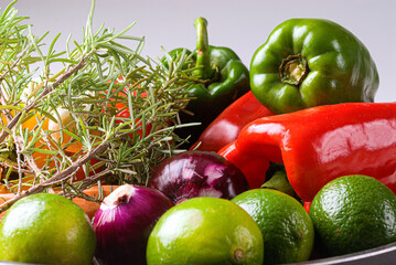 .Green and red peppers, onion, lemon, rosemary, recipe ingredients on white background.