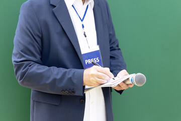 TV journalist or television reporter holding microphones at press conference or media event....