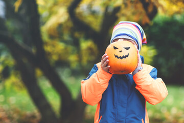 happy cute little kid boy with halloween pumpkin lantern on autu