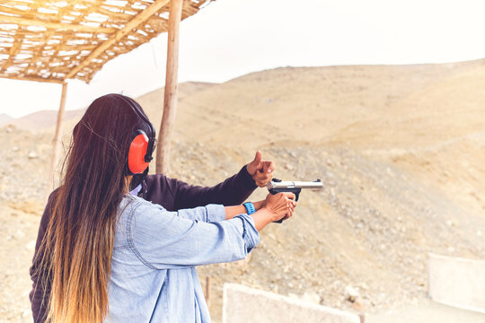 Woman releasing stress, Instructor helping woman with gun