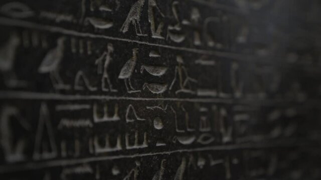 Macro close up of ancient Egyptian hieroglyphics symbols written on wall