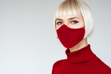 Woman wearing trendy fashion outfit with red cloth protective handmade face mask during quarantine...