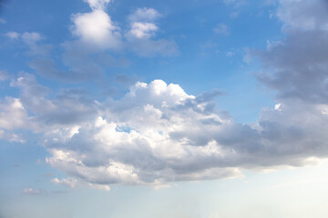 Naklejka na ściany i meble Fluffy cumulus clouds on blue sky background. Cloudscape white and grey color