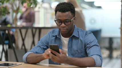 African Man using Smartphone in Modern Office 