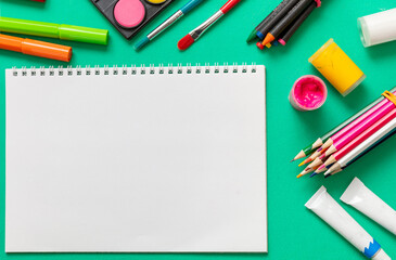 Creative kids, painting and drawing. Colorful paints and brushes on green color background, empty...