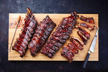 Barbecue pork spare loin ribs St Louis cut with hot honey chili marinade served as top view on a wooden board