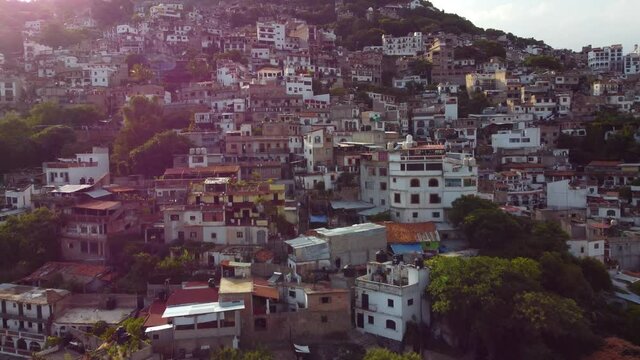 Taxco is a town in the state of Guerrero, famed for Spanish colonial architecture. Climbing the hill from the air. Cinematic with lens flare.