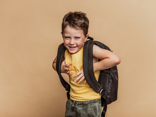 Smiling pupil with backpack in studio