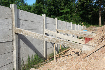 Concrete wall fence to prevent soil erosion with concrete stay help fix the problem slanted fence.