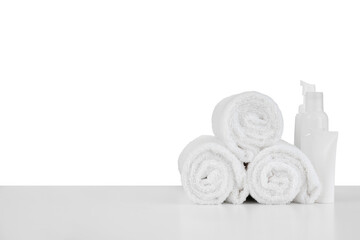 Composition of cosmetic bottles and towels isolated on white