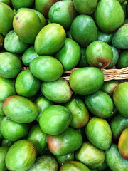 A lot of green mango on sale at farms market. Food background. Mobile photo