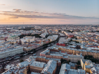 Obraz premium Sunset landscape of Fontanka river and old houses in St Petersburg. Boats float on the water. Russia in the summer. Place for tourism. Nevsky prospect on background. Cloudy sky. View from above.