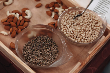 Pine nuts in a glass plate on a wooden table. Organic food.