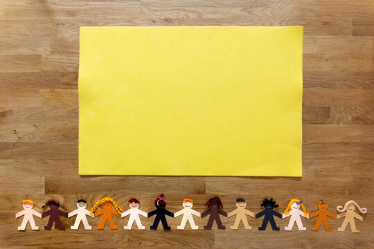 An empty yellow cardboard with a multi-ethnic human paper chain at the bottom of the image