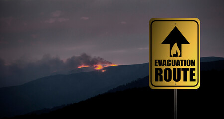 Evacuation route sign with forest fire at night. Warning. Alert. Copy space. Banner.