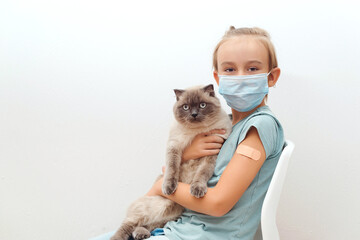 Boy with cat sitting at chair after vaccine. Kid vaccinated against coronavirus infection.