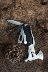 multi purpose tool on rustic wooden table ,camping and survival tools for every day .
