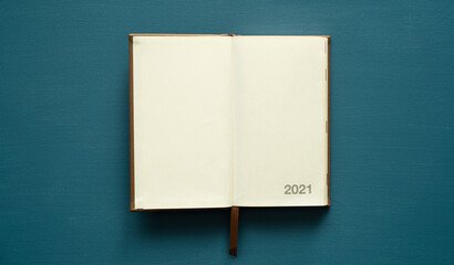 calendar 2021 with space for text, brown tab, on a dark turquoise background, photo from above