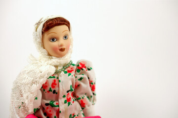 Portrait of a porcelain doll. Doll in a white shawl