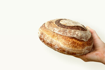 Female hand holding bread. Bread with a heart. Healthy food concept. Copy space. Space for text. Sourdough bread