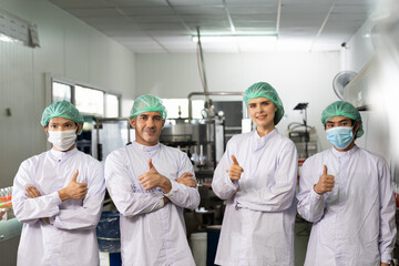 Group of diversity factory worker wearing white uniform and hairnet at  beverage factory. Portrait...