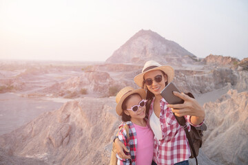 Taking selfie! happy mother and daughter making self portrait in the mountains. woman holding...