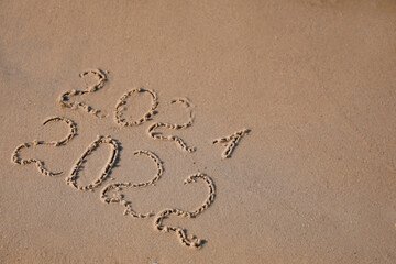2021 and 2022 written on sand at beach, above view. New Year celebration
