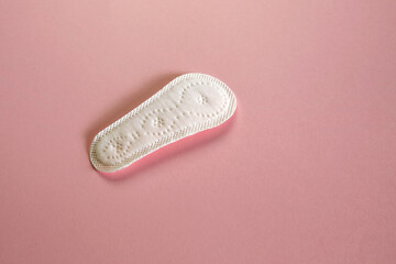 panty liner, women's hygiene product on pink paper texture