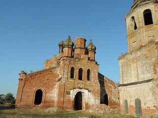 Fototapeta na wymiar An abandoned church and a red brick bell tower in the deep province.