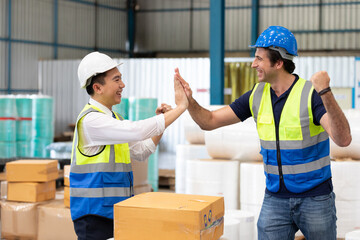 factory workers or engineers giving high five pose together in warehouse storage